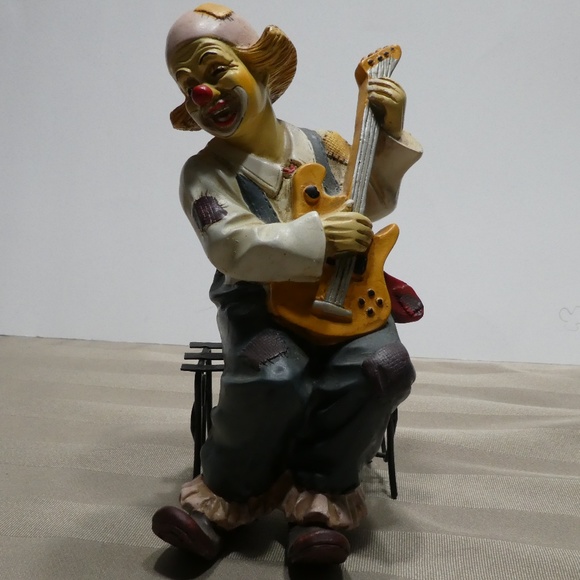 CLOWN porcelain sitting on bench playing guitar